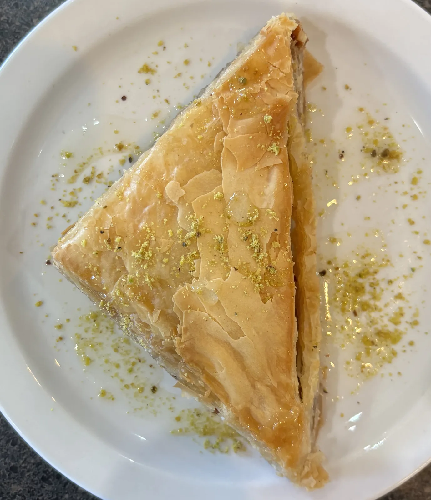 Baklava with walnuts and honey on a beige background. Traditional East desert in wooden dish. Copy space.