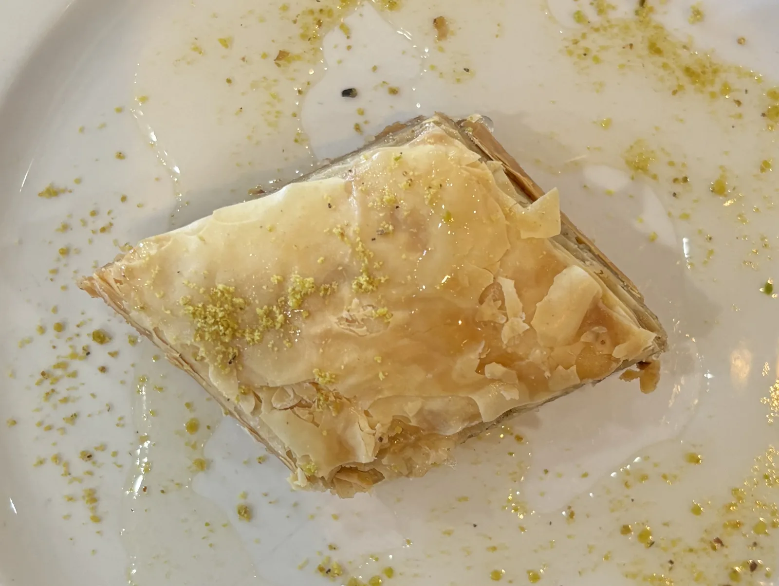 Baklava with walnuts and honey on a beige background. Traditional East desert in wooden dish. Copy space.